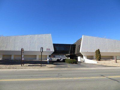 A large white building is sitting on the side of a road.