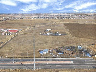 An aerial view of a rural area with a highway in the foreground