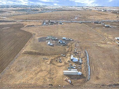 An aerial view of a dirt field with a lot of trucks in it