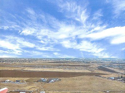 An aerial view of a desert landscape with a blue sky and white clouds