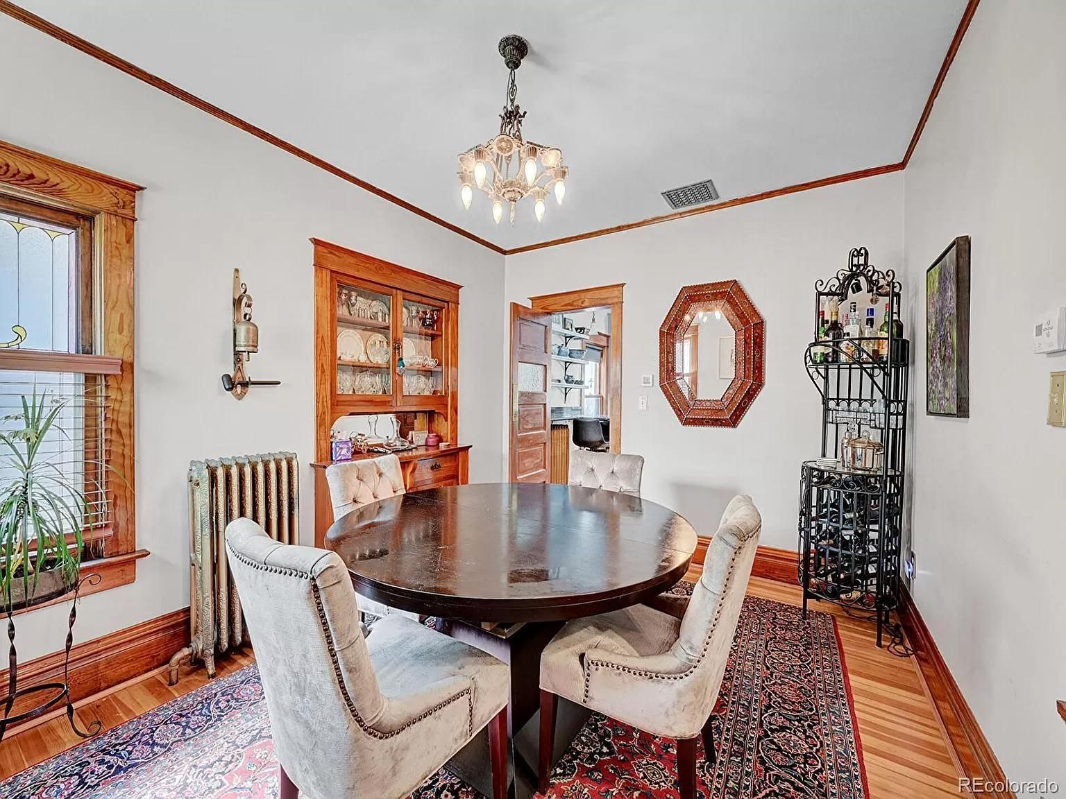 A dining room with a round table and chairs and a chandelier.