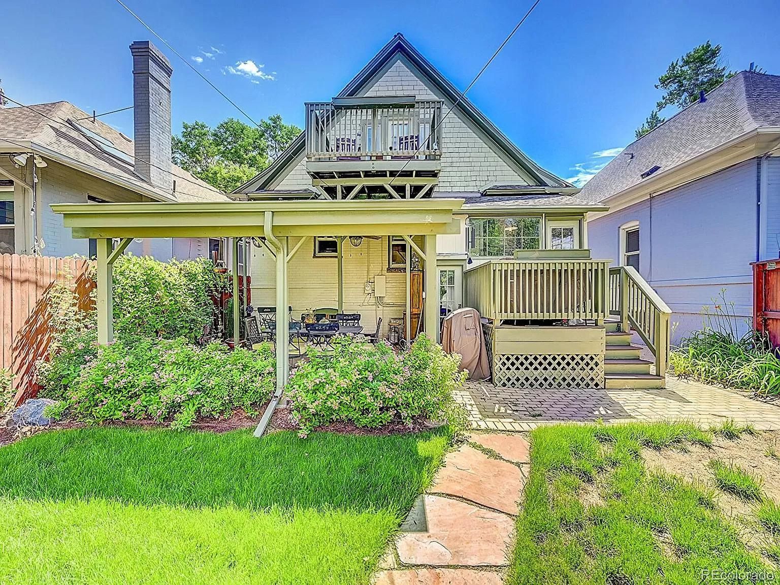 The back of a house with a porch and a walkway leading to it.