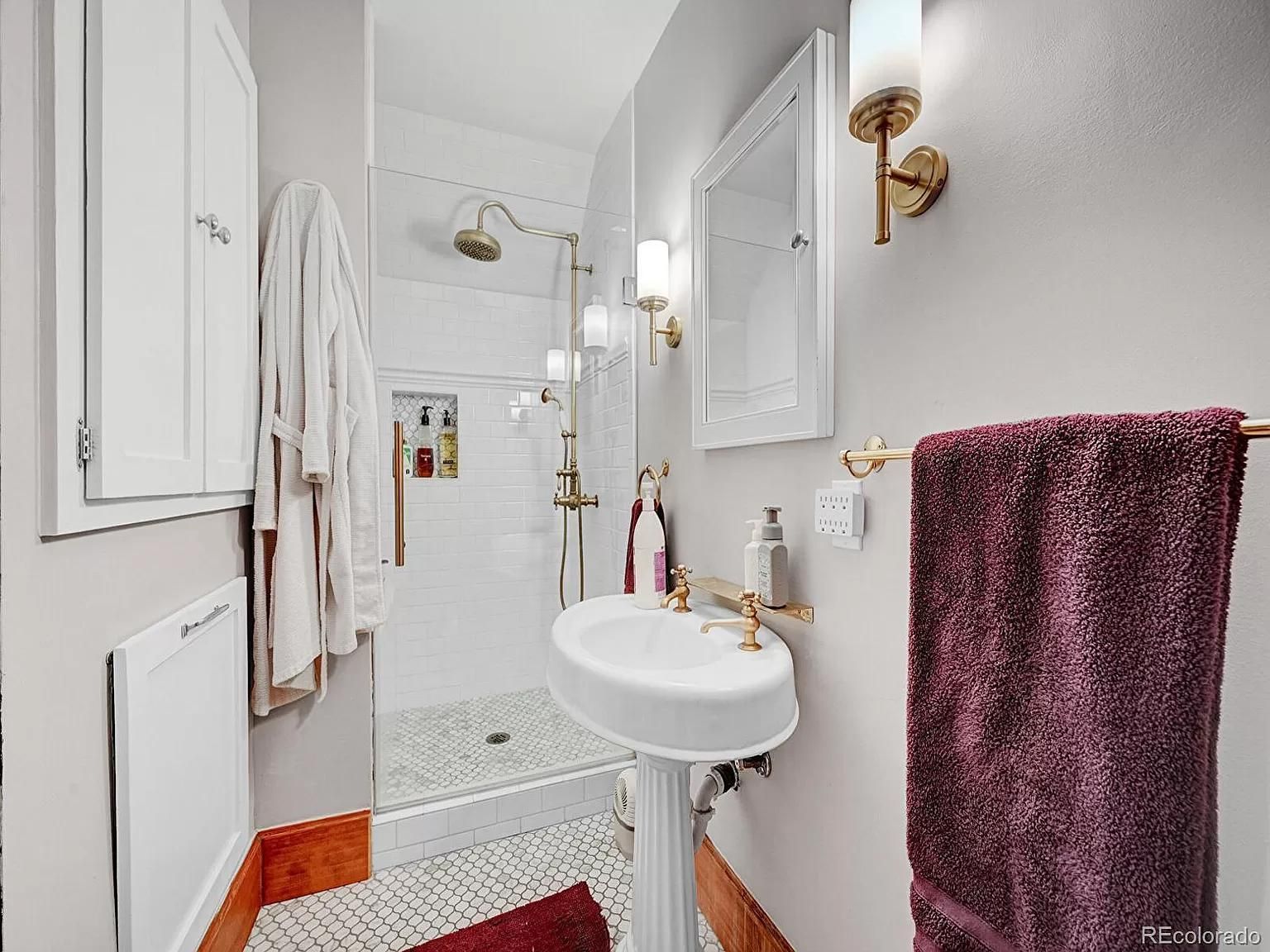 A bathroom with a sink , mirror , and shower.