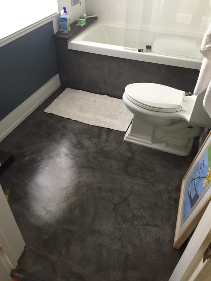 A bathroom with a toilet a bathtub and a picture on the wall