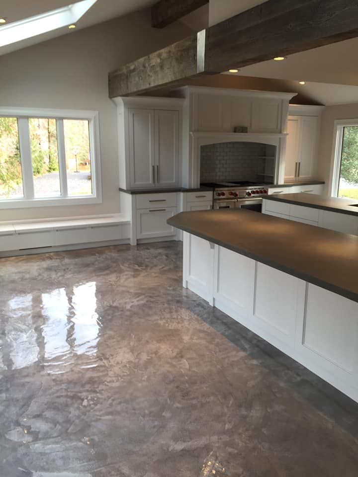 A kitchen with white cabinets and brown counter tops