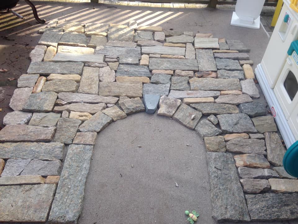 A stone archway is being built on a patio