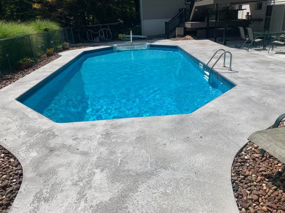 A large blue swimming pool with a concrete deck