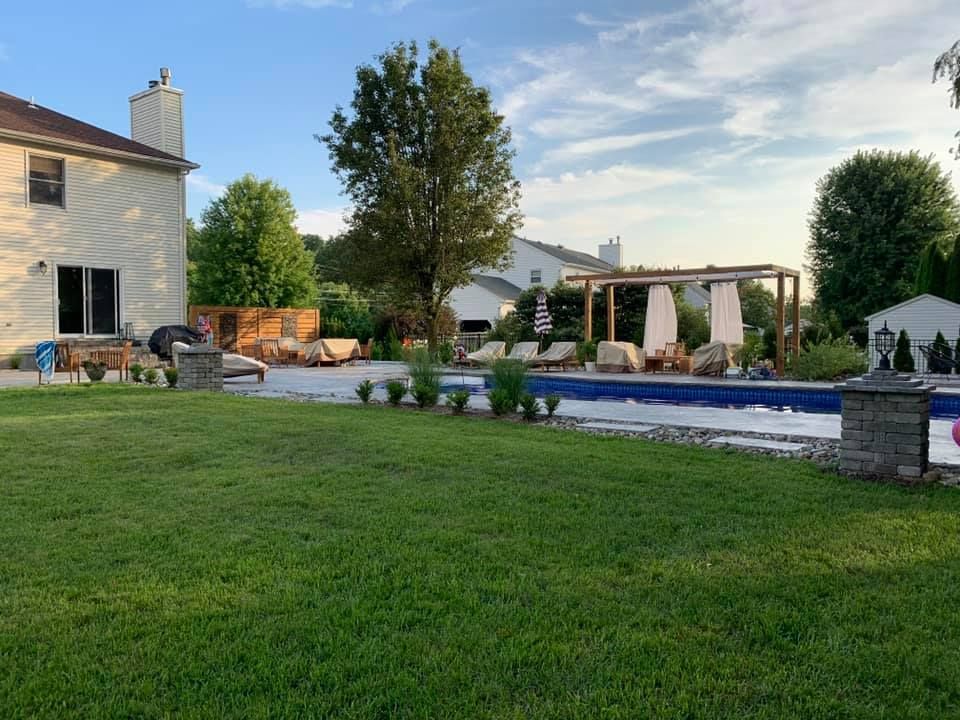 There is a large swimming pool in the backyard of a house.
