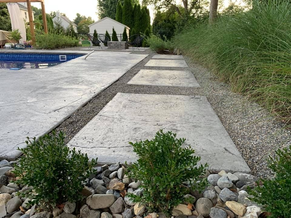 A concrete walkway leading to a swimming pool