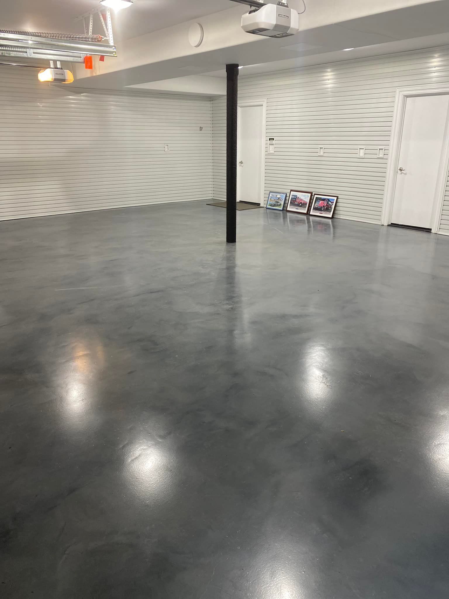 An empty basement with a gray floor and white walls