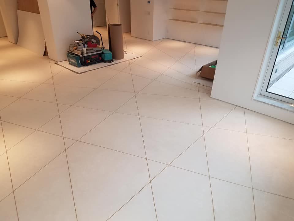 A white tiled floor in a room with a window