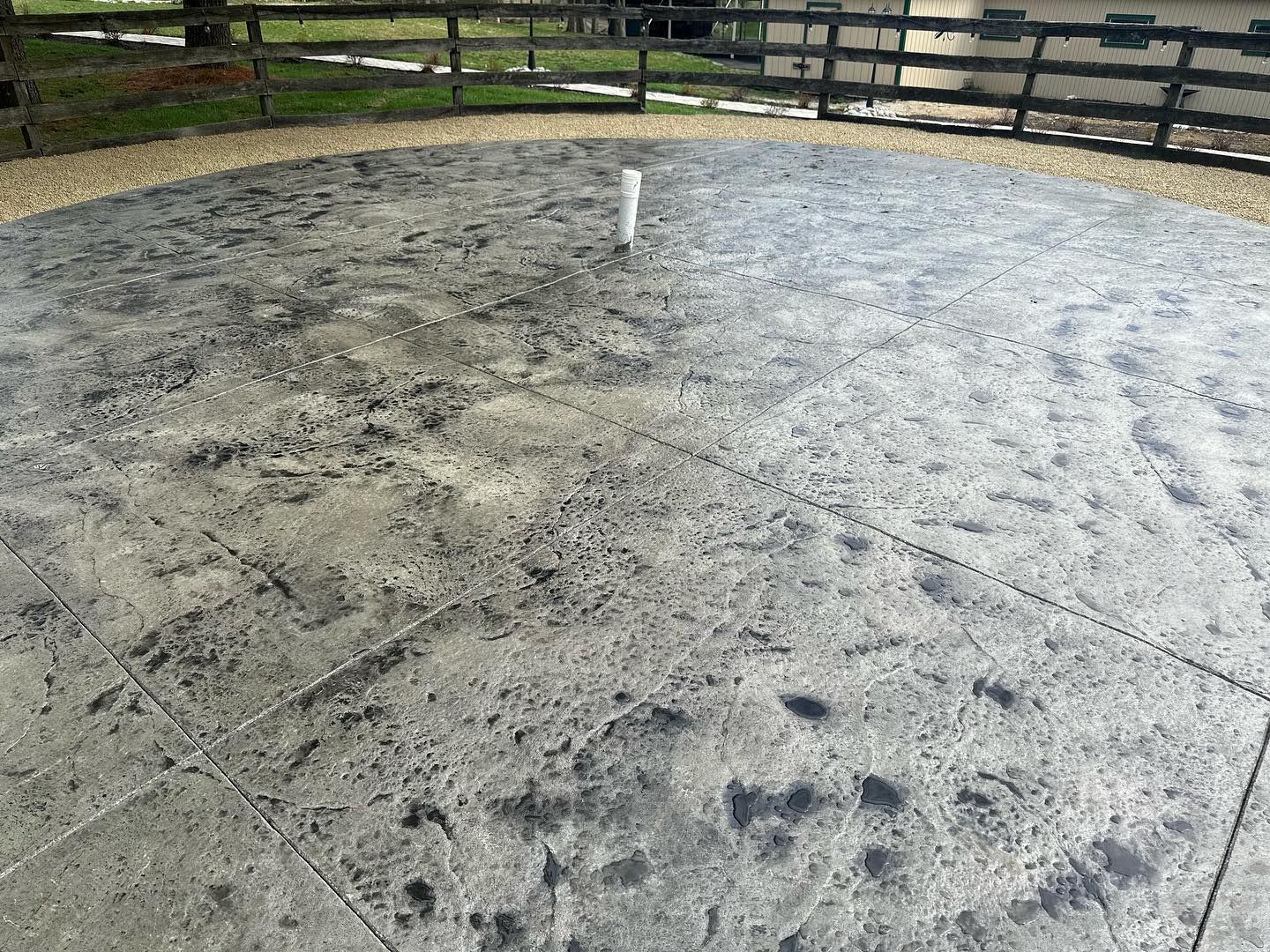 A concrete patio with a wooden fence in the background.