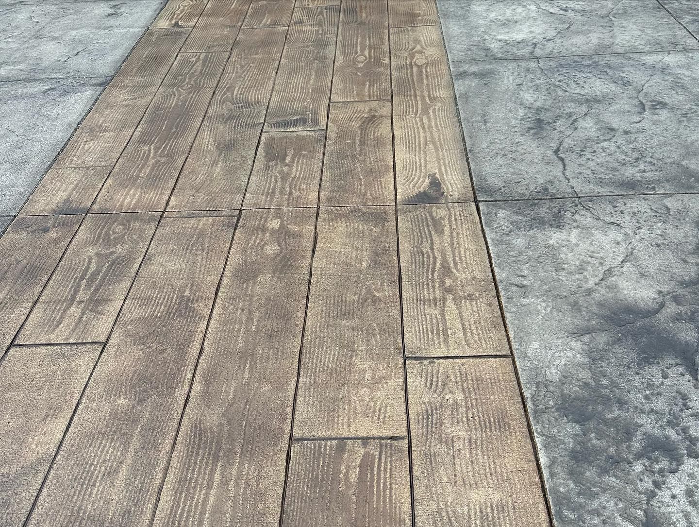 A wooden walkway next to a concrete walkway.