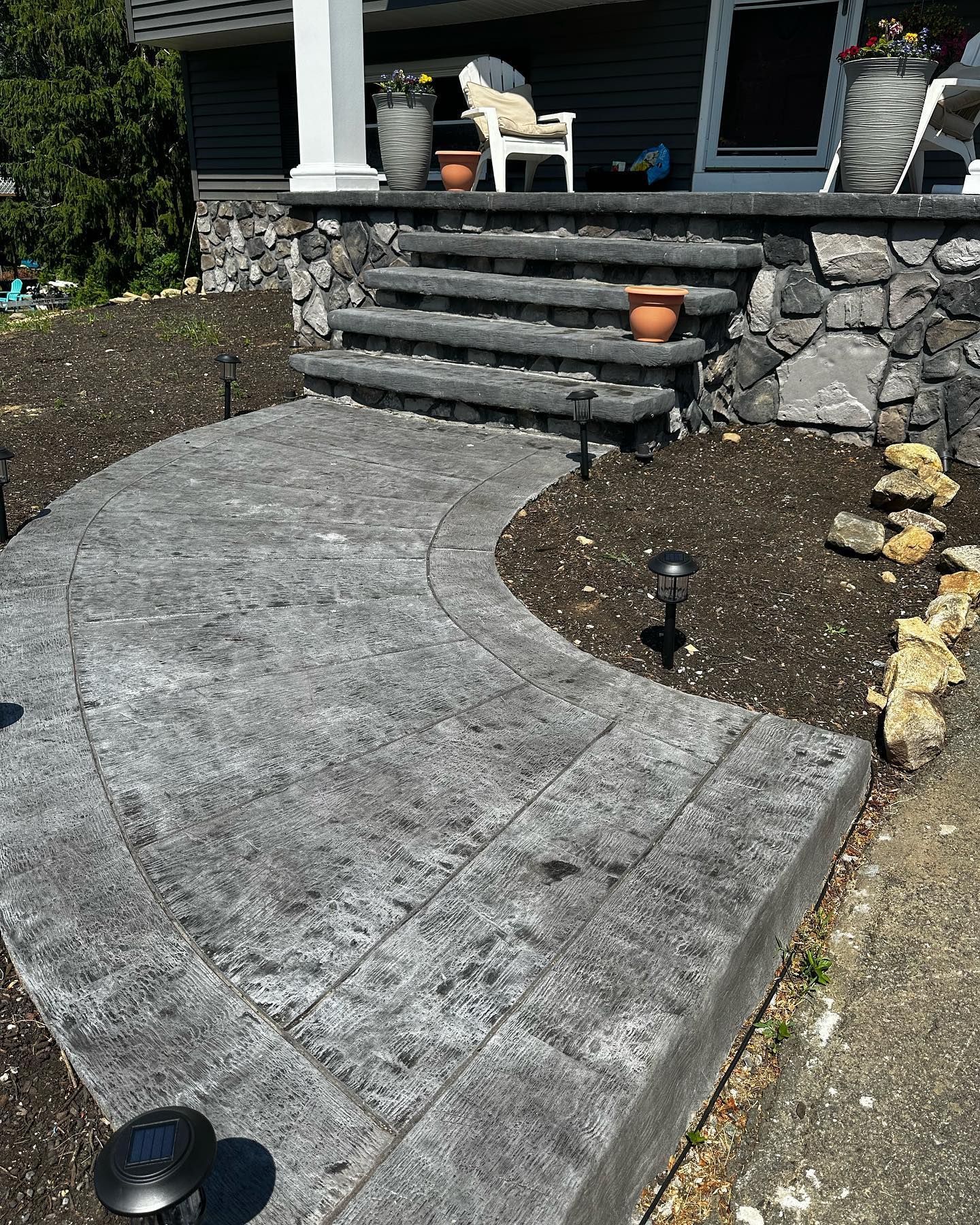 A concrete walkway with stairs leading up to a house.