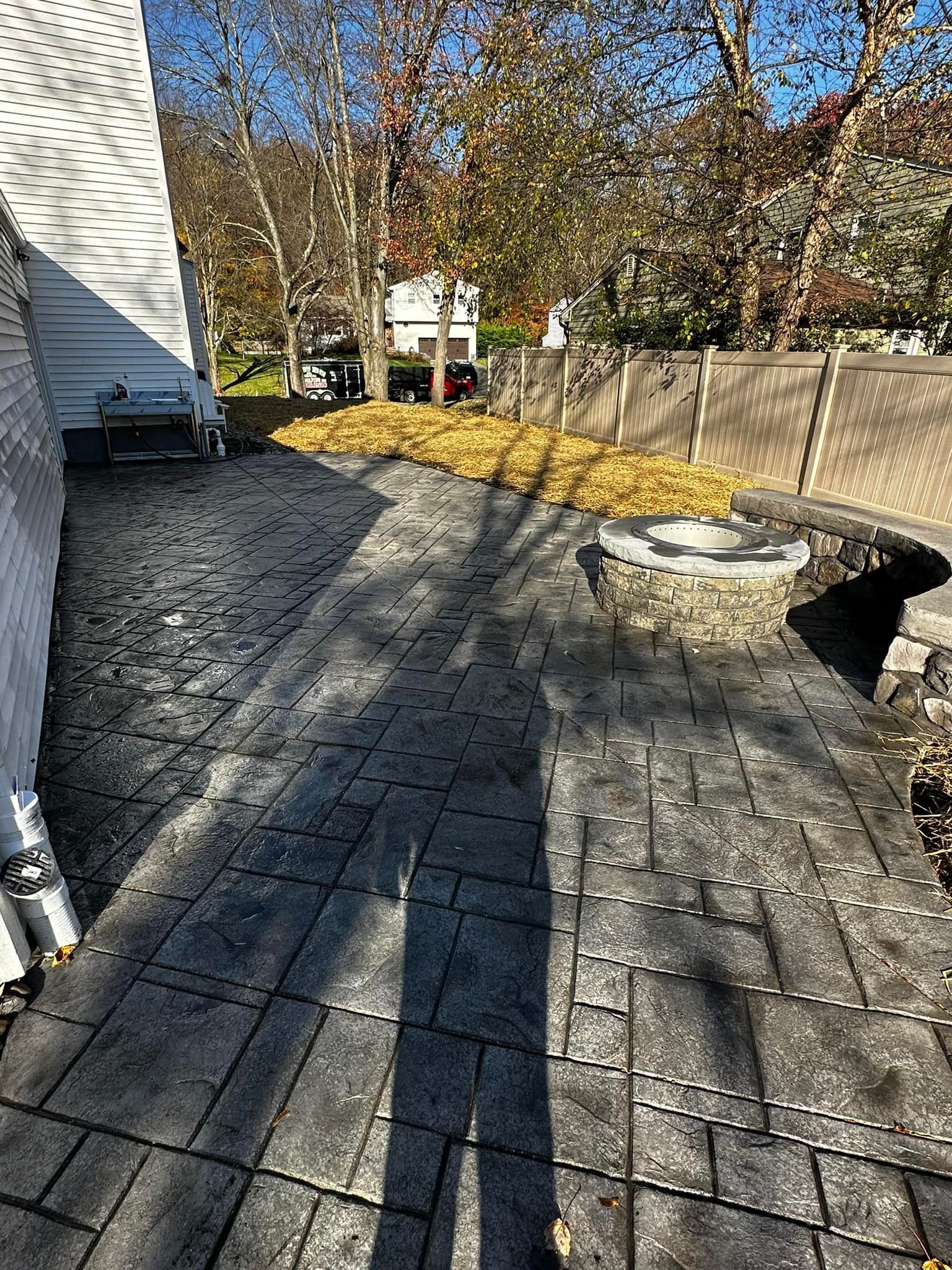 A shadow of a person is cast on a brick walkway next to a house.