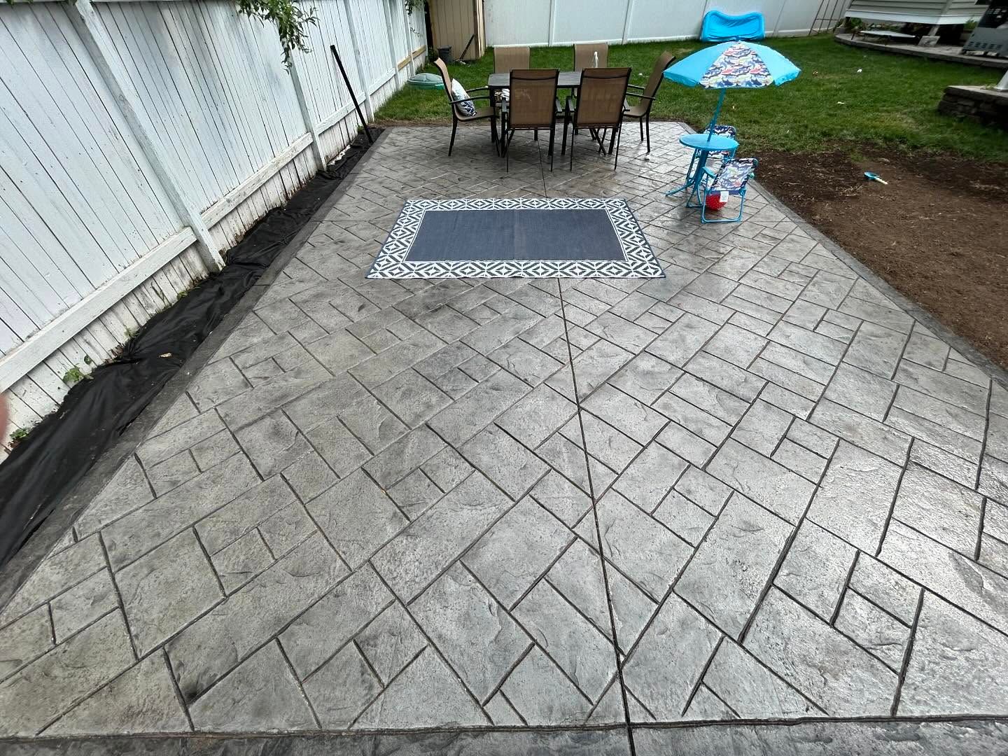 A patio with a table and chairs and an umbrella.