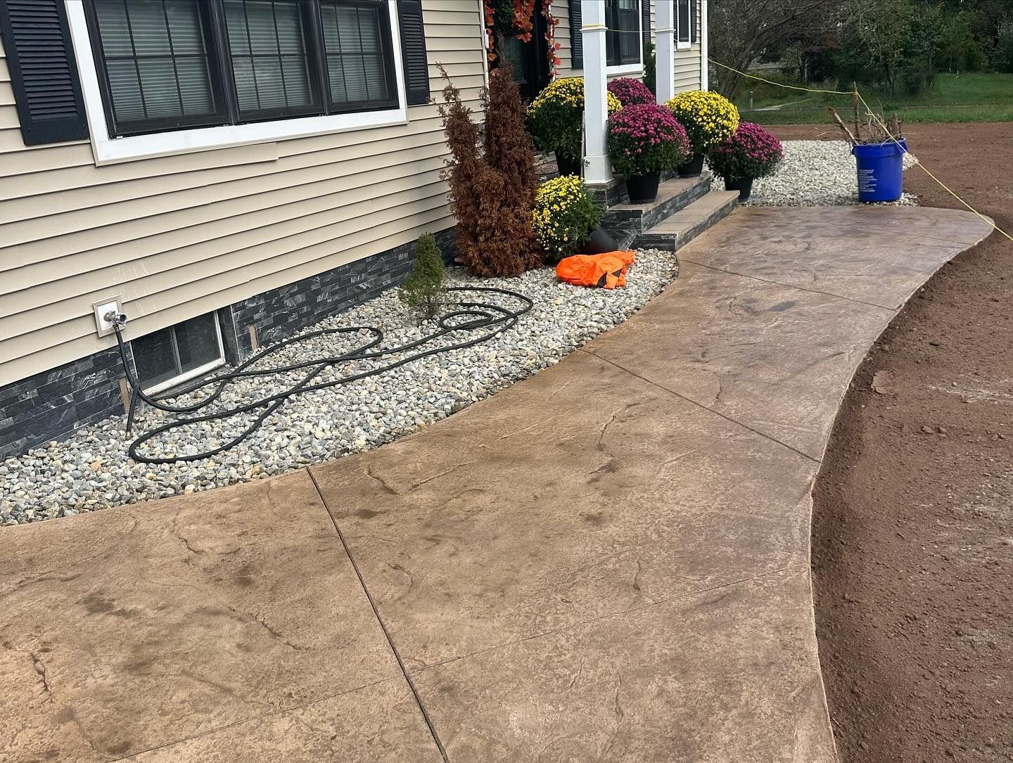 A concrete walkway leading to the front door of a house.