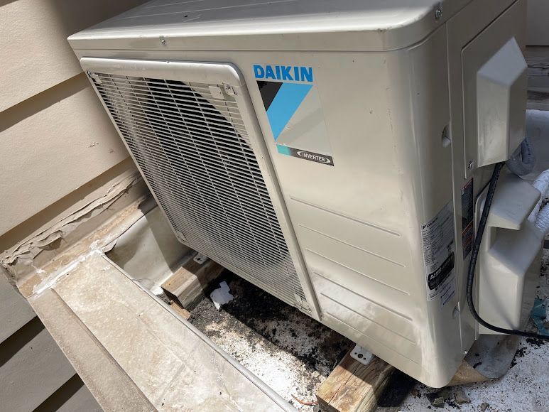 A daikin air conditioner is sitting on top of a wooden pallet.