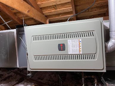 A gas furnace is sitting in the attic of a house.