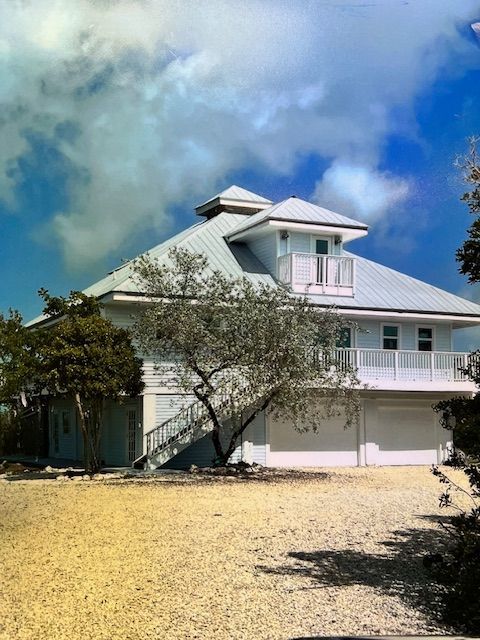 A large white house with a blue sky in the background
