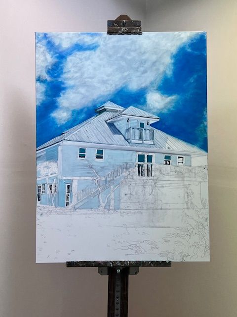 A painting of a house is being painted on an easel