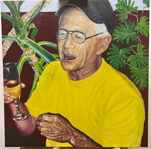 A man in a yellow shirt is holding a glass of wine