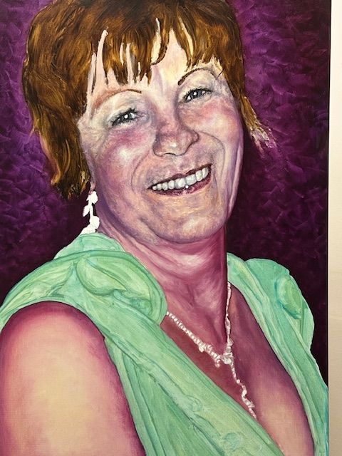 A woman in a green dress is smiling in a painting