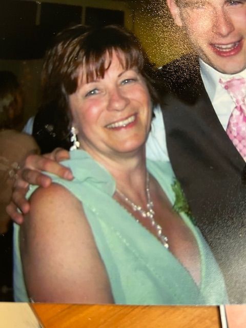 A woman in a green dress is smiling next to a man in a suit