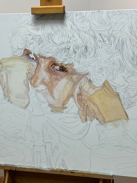 A painting of a woman 's face is being painted on an easel.