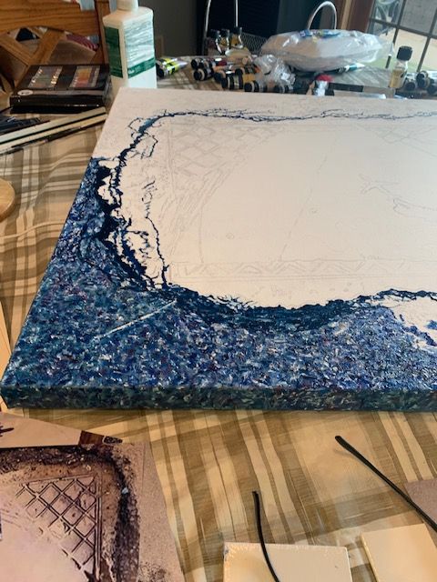 A painting is being painted on a canvas on a table