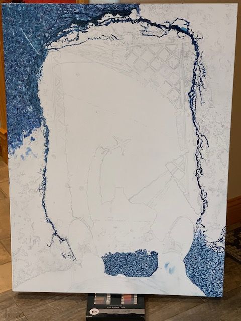 A blue and white painting is being painted on a canvas
