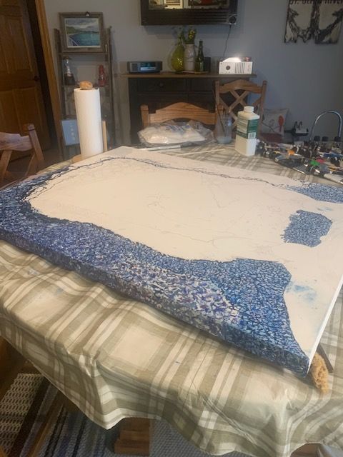 A painting is sitting on a table with a plaid tablecloth.