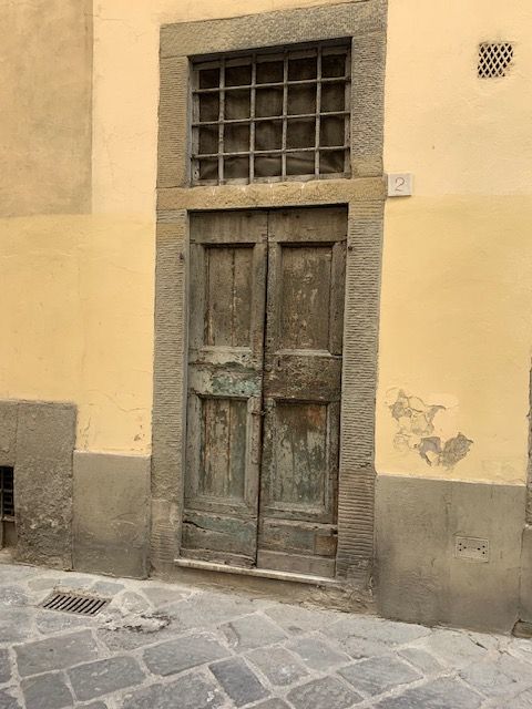 An old wooden door with a window on the side of a building.