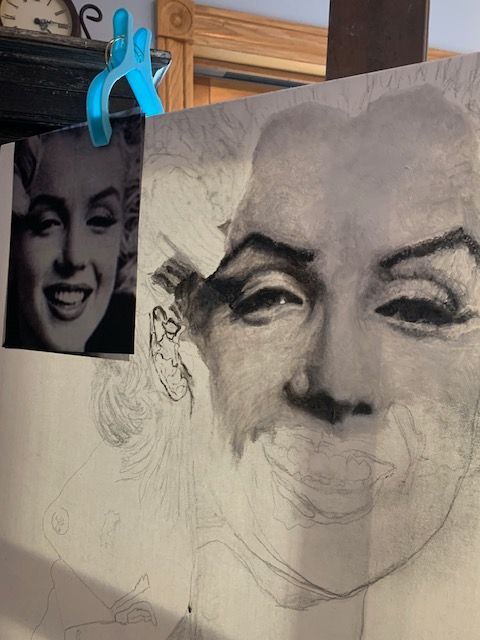 A drawing of marilyn monroe is hanging on a clothesline