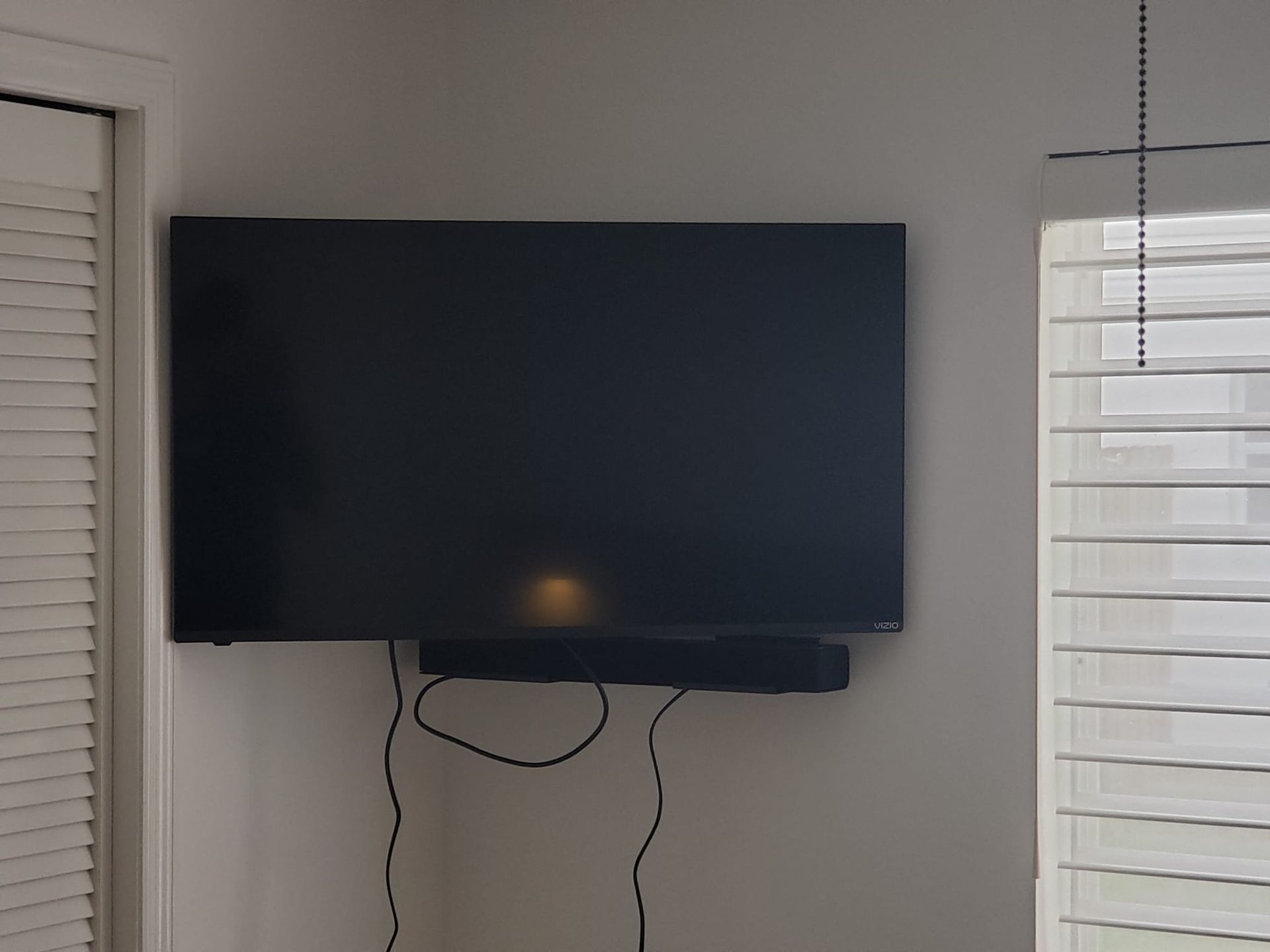 A flat screen tv mounted on a wall next to a window