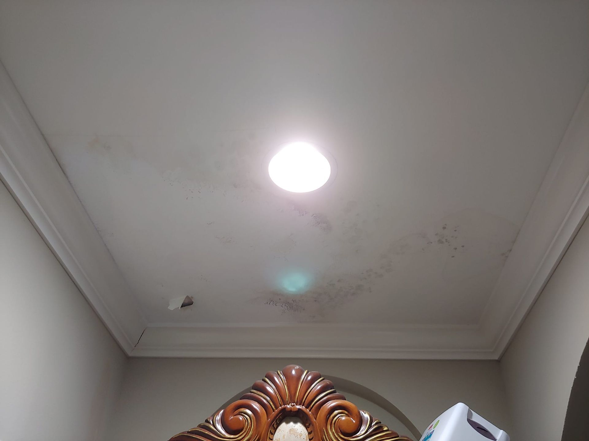 A room with a clock on the wall and a light on the ceiling.