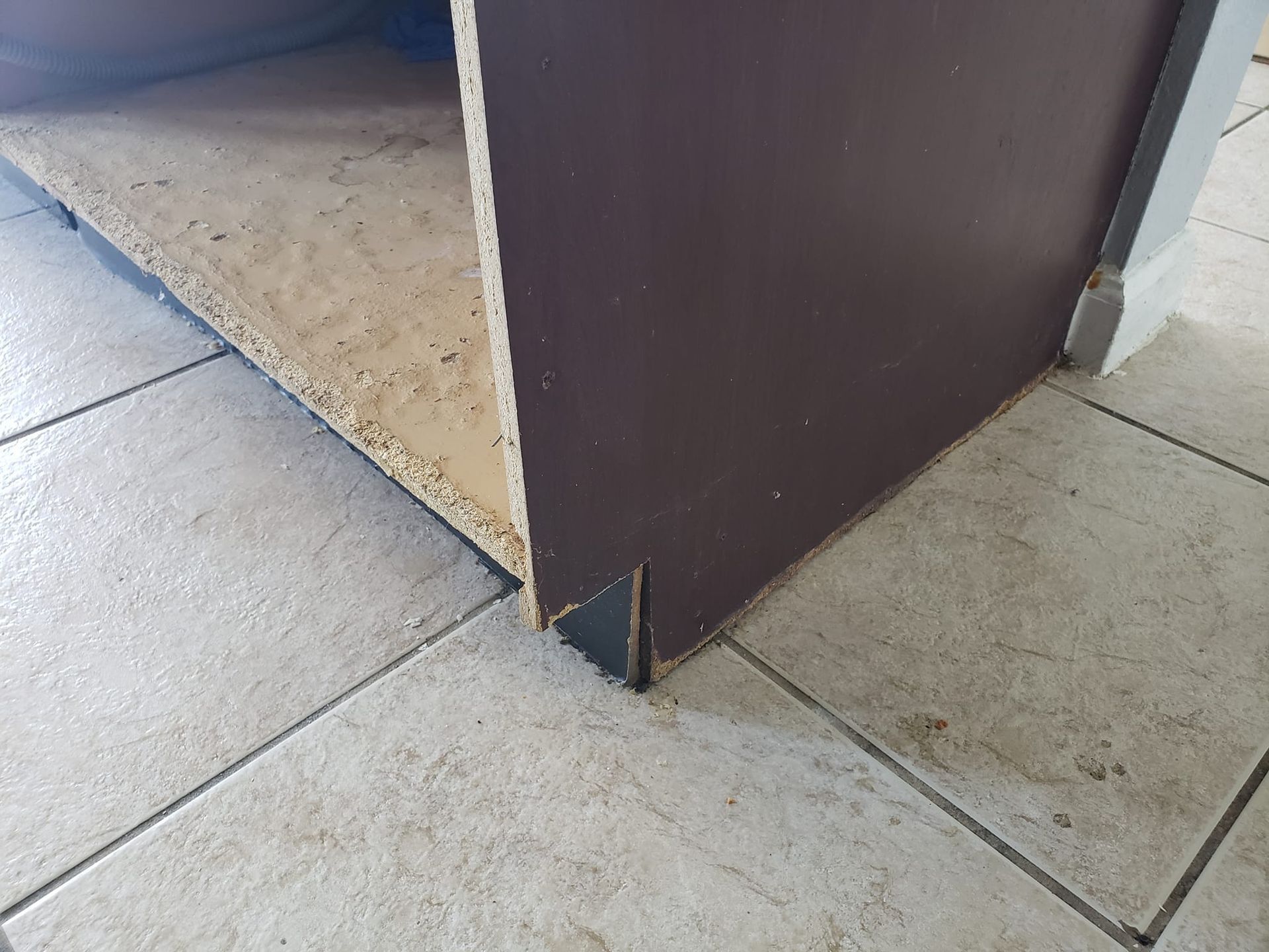 A close up of a piece of wood on a tiled floor.