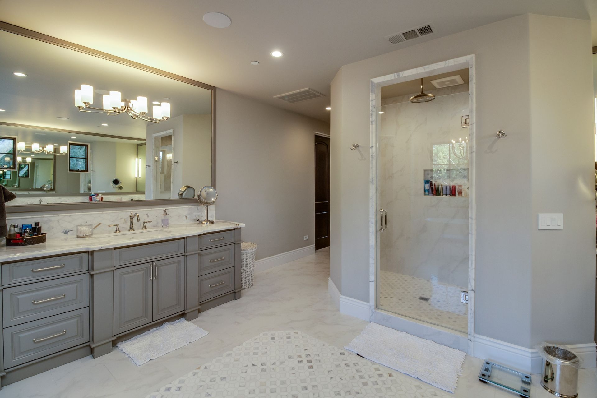 A bathroom with two sinks and a walk in shower.