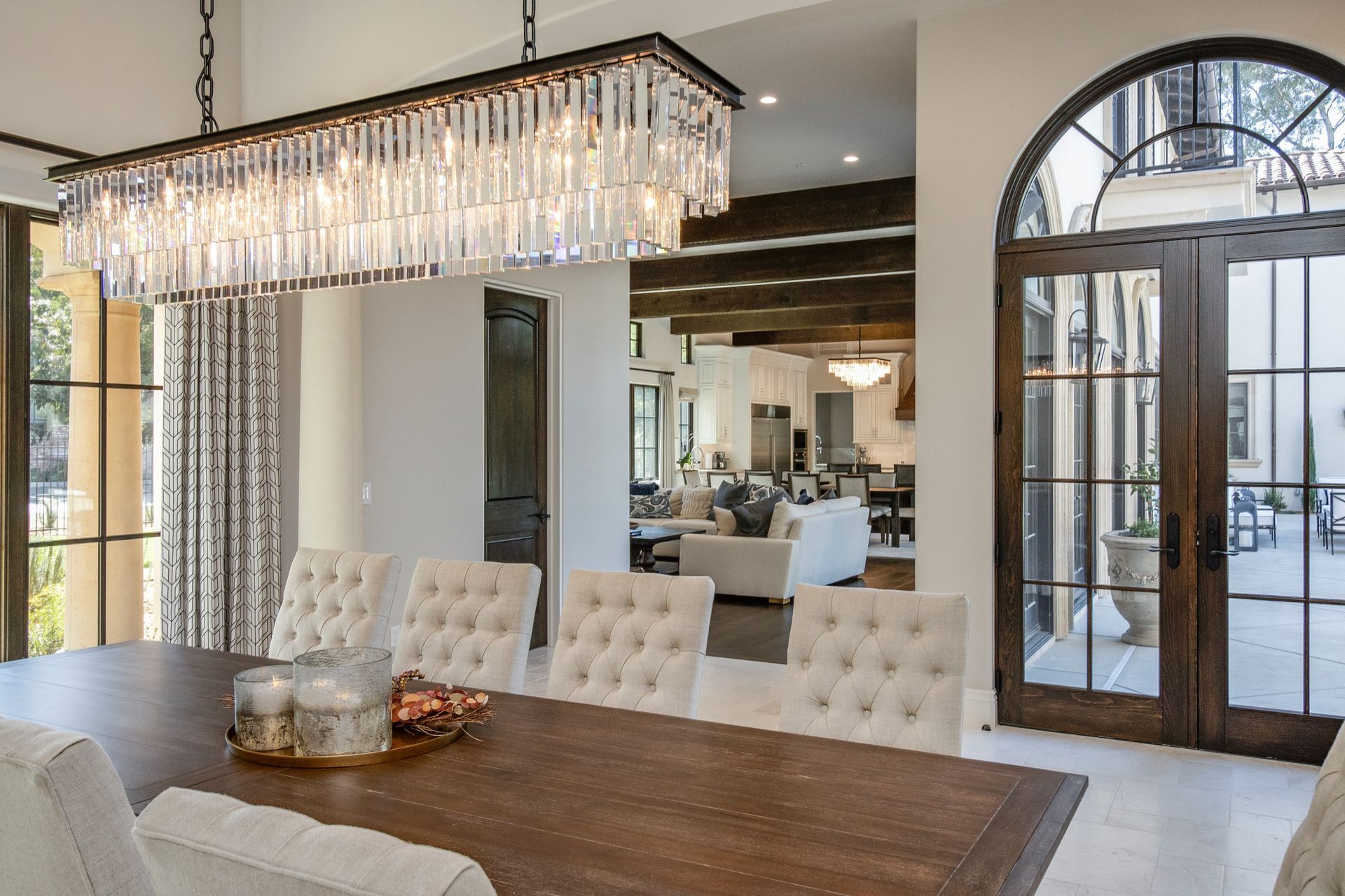 A dining room with a table and chairs and a chandelier hanging from the ceiling.