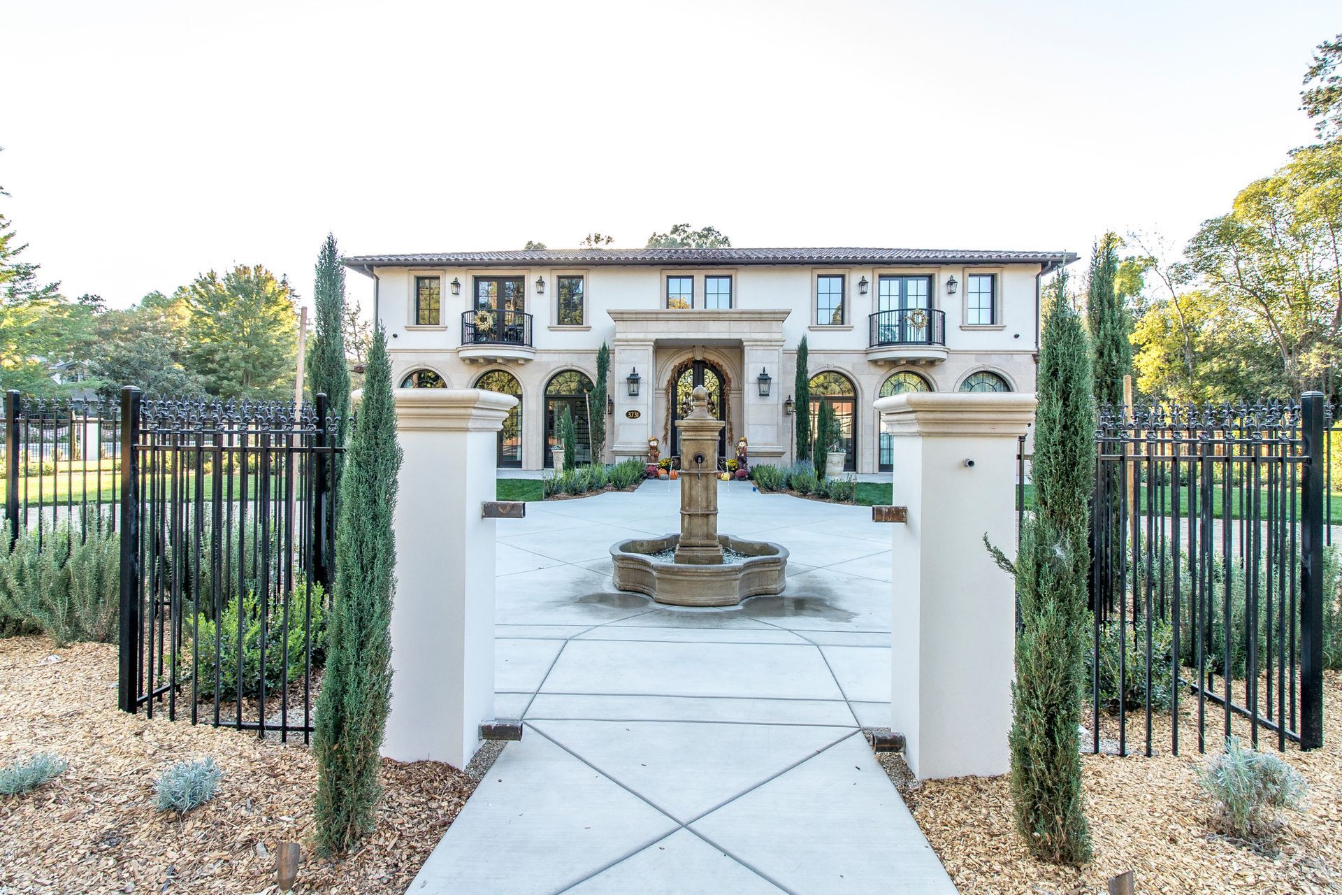 A large white house with a fountain in front of it