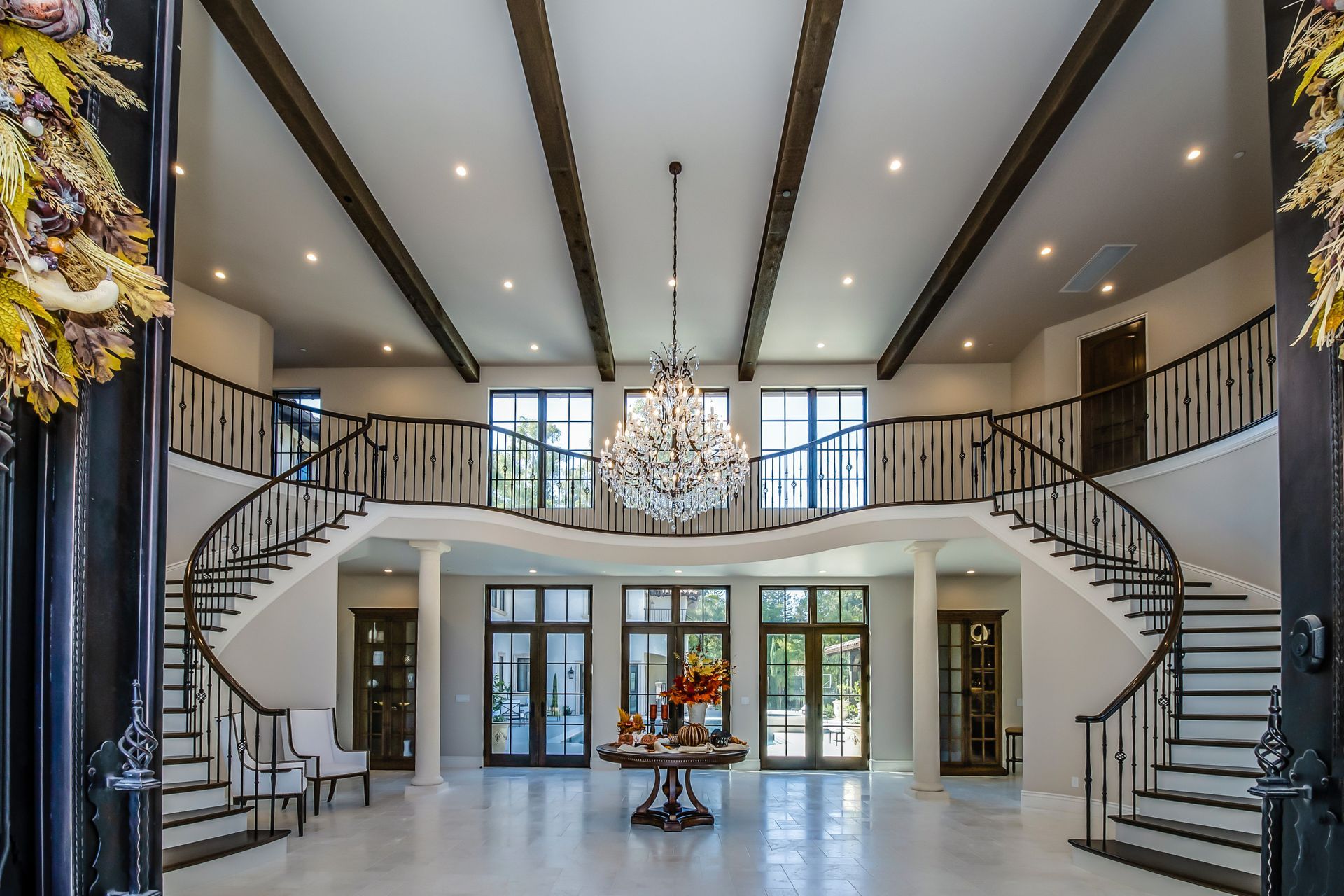 A large room with stairs and a chandelier hanging from the ceiling.