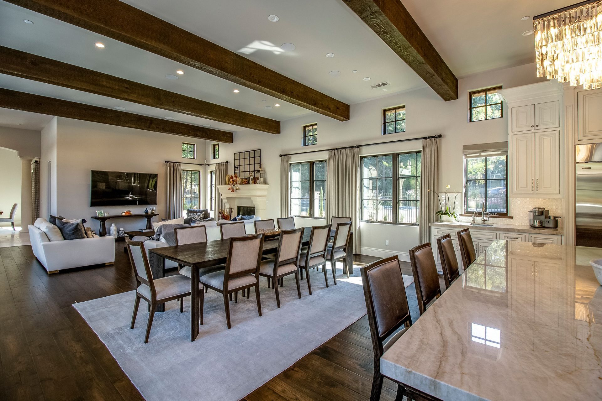 A large living room with a dining table and chairs and a kitchen.