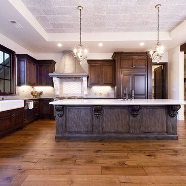 A kitchen with wooden cabinets , a large island , a sink and a stove.