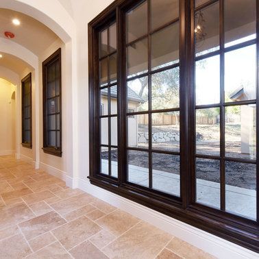 A hallway with lots of windows and a tiled floor