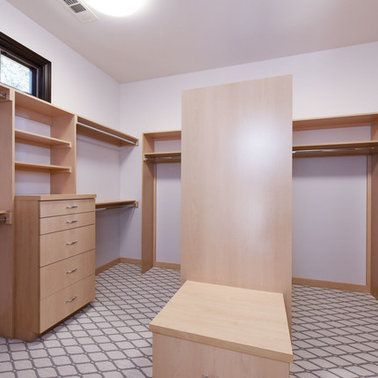 A walk in closet with lots of shelves and drawers