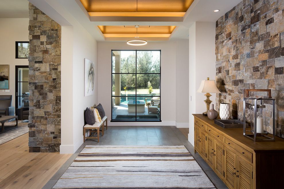 A hallway in a house with a large window and a rug.