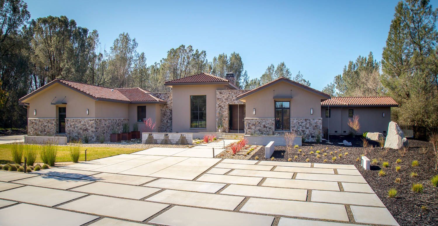 A large house with a brick driveway in front of it