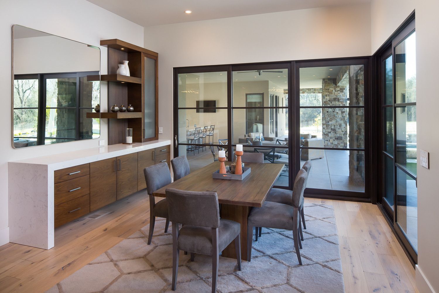 A dining room with a table and chairs and sliding glass doors