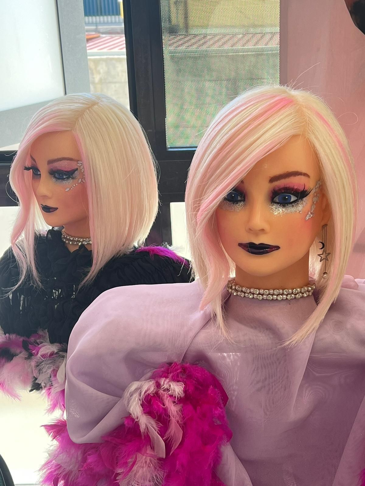 Due manichini con i capelli rosa sono seduti uno accanto all'altro