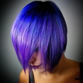 Una donna con i capelli blu e viola indossa una canottiera nera.